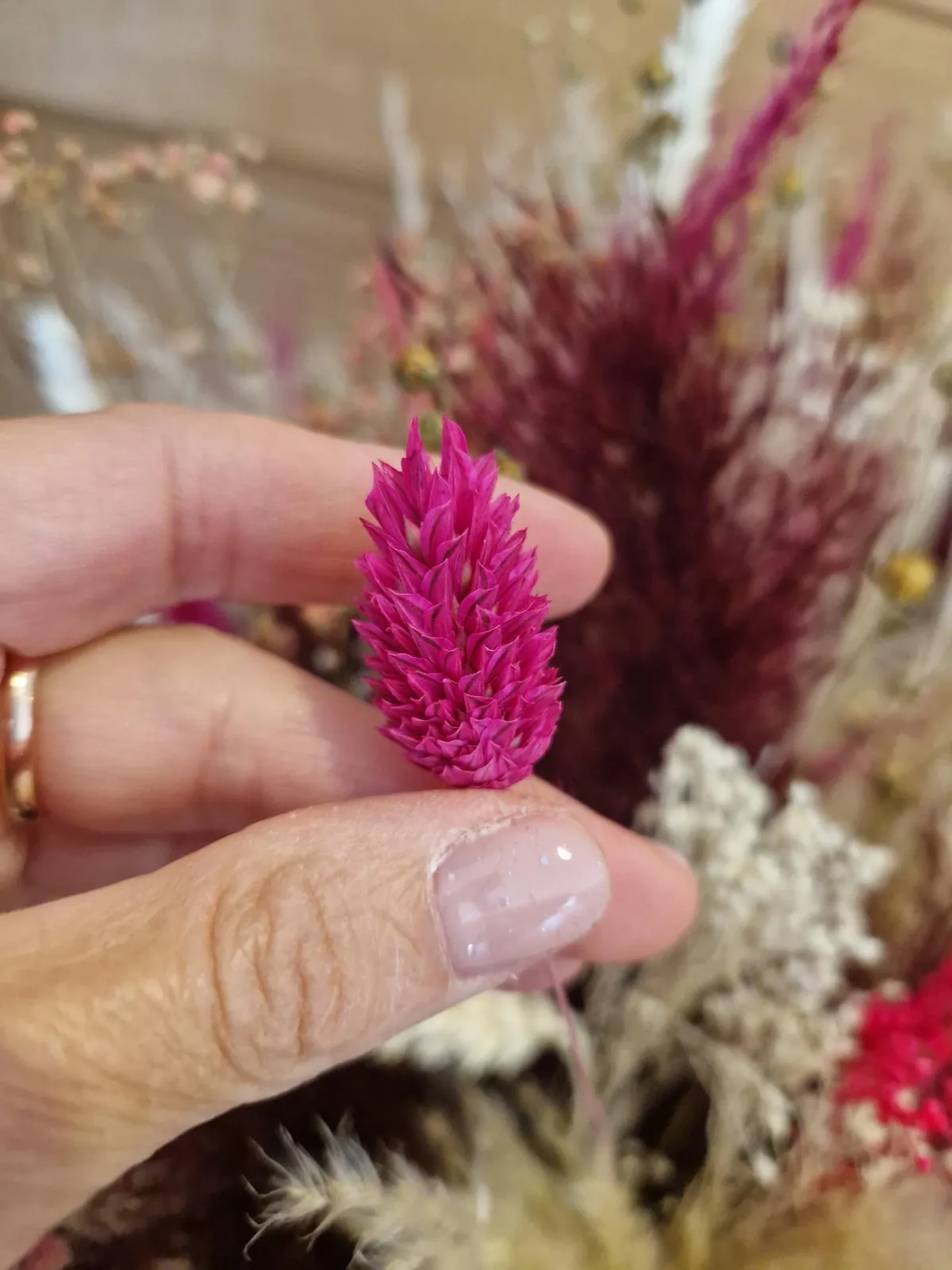 Les mains d'Hélène composant une fleur séchée