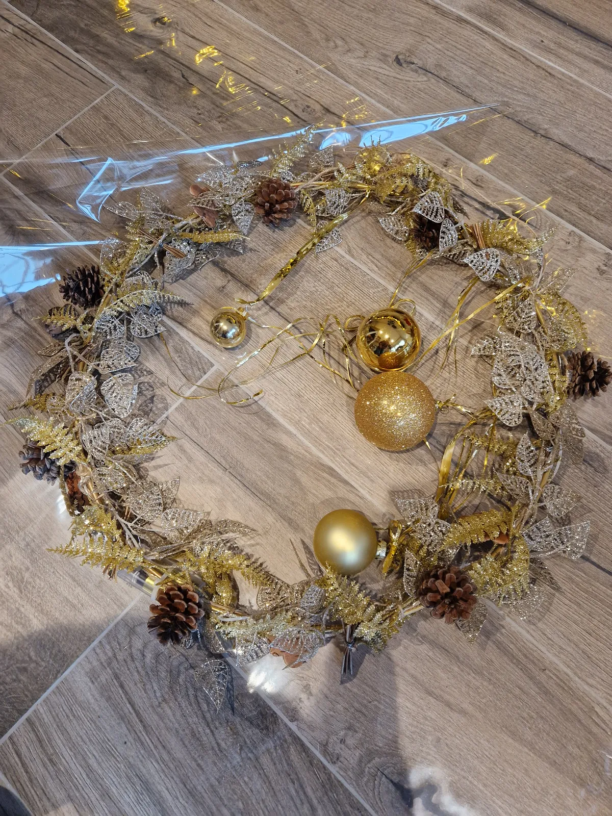 Couronne dorée aux boules et pommes de pin