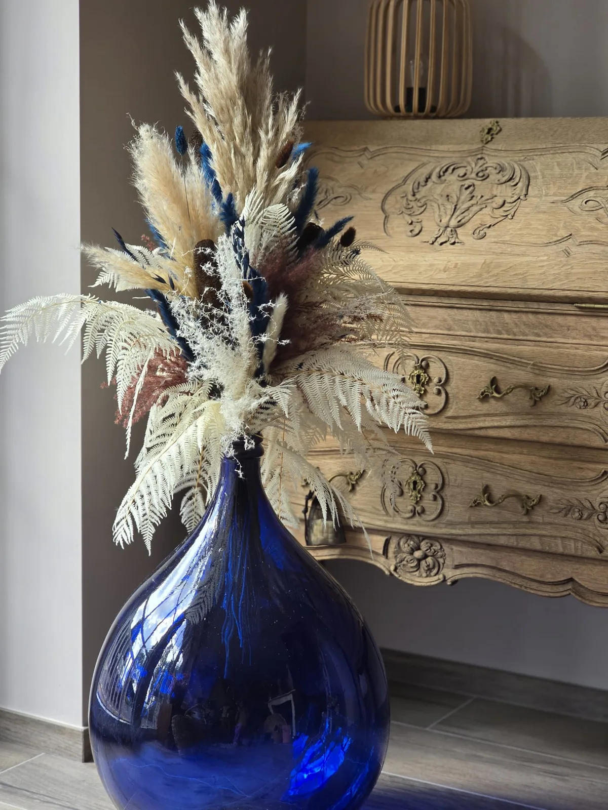 Dame-jeanne bleue relookée, fougères blanches et pampas